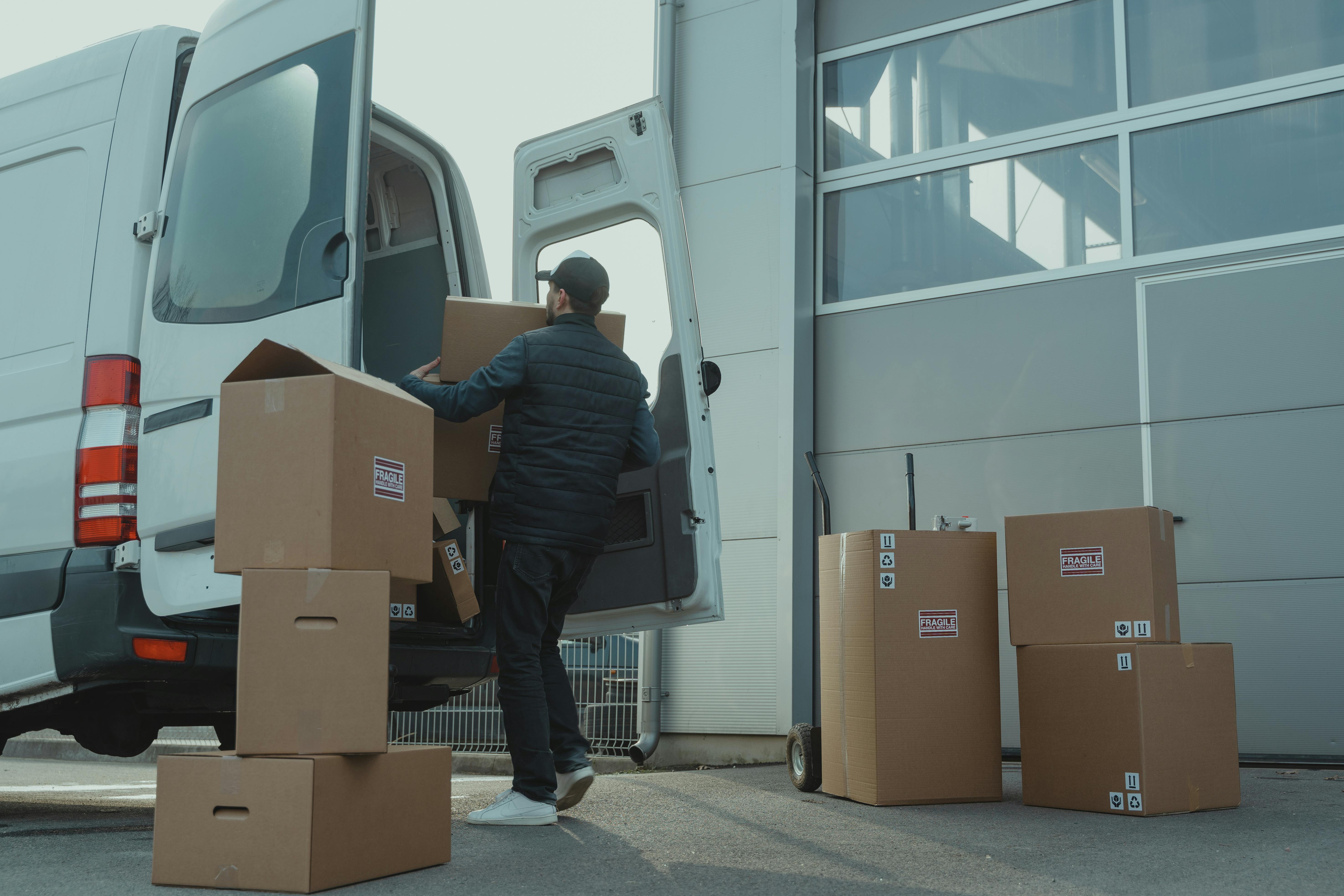 Mover carefully loading packed boxes into a van